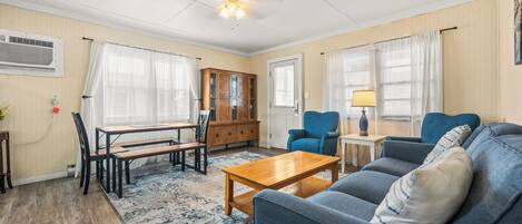 A living room with a wooden coffee table, blue sofa, and a cabinet.