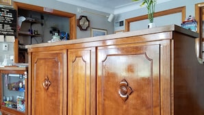 Un mostrador de recepción de madera con un reloj y un letrero en el fondo.