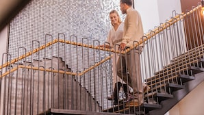 A staircase with a patterned wall and metal railings. - Canopy by Hilton Reykjavik City Centre (Reykjavik)