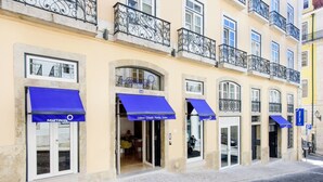 A row of buildings with blue awnings, each labeled 'Lisbon Chiado Family Suites'. - Martinhal Lisbon Chiado (Lisbon)