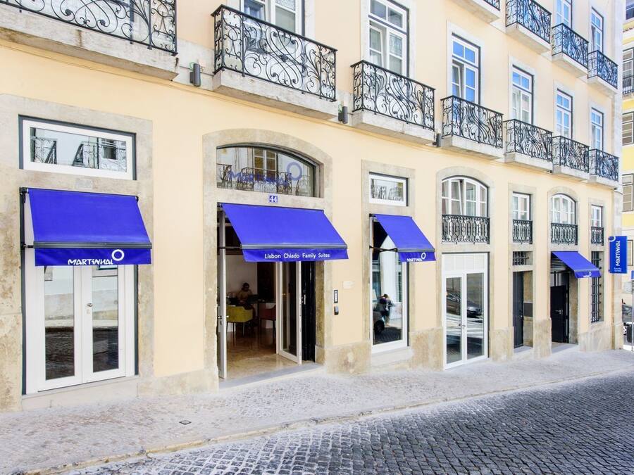 Una hilera de edificios con toldos azules, cada uno con la leyenda 'Lisbon Chiado Family Suites'.