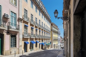 A street with buildings featuring balconies, awnings, and a cobblestone road. - Martinhal Lisbon Chiado (Lisbon)
