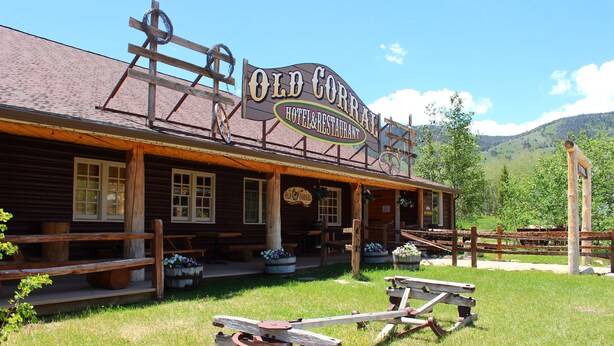 Un edificio de madera rústico con un letrero que dice "Old Corrie Hotel & Restaurant".