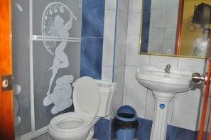 A bathroom with a toilet, sink, and a blue trash bin. - Hotel Coca Imperial (Coca)