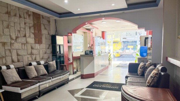 A hotel lobby with a stone wall, a reception desk, a sofa, and a coffee table. - Hotel Coca Imperial (Coca)