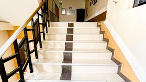 A staircase with white steps and dark risers, leading to a landing with a handrail on the left. - Hotel Coca Imperial (Coca)