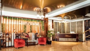 A hotel lobby with a reception desk, seating area, and a staircase. - Hotel Libertador (Loja)