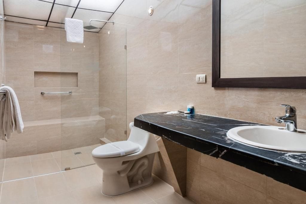 Un baño moderno con ducha, inodoro y lavamanos.
