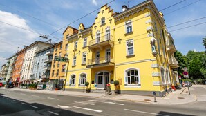 A yellow building with multiple floors, large windows, and a balcony. - Hotel Lehenerhof Salzburg (Salzburg)