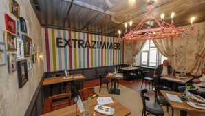 A restaurant interior with striped walls, wooden tables, and a chandelier. - Hotel Lehenerhof Salzburg (Salzburg)
