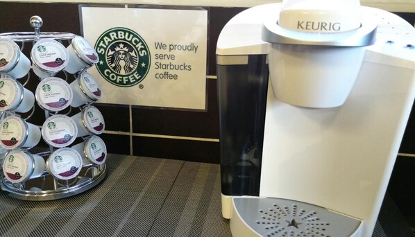 Een koffieapparaat en een dispenser voor Starbucks koffiepads.