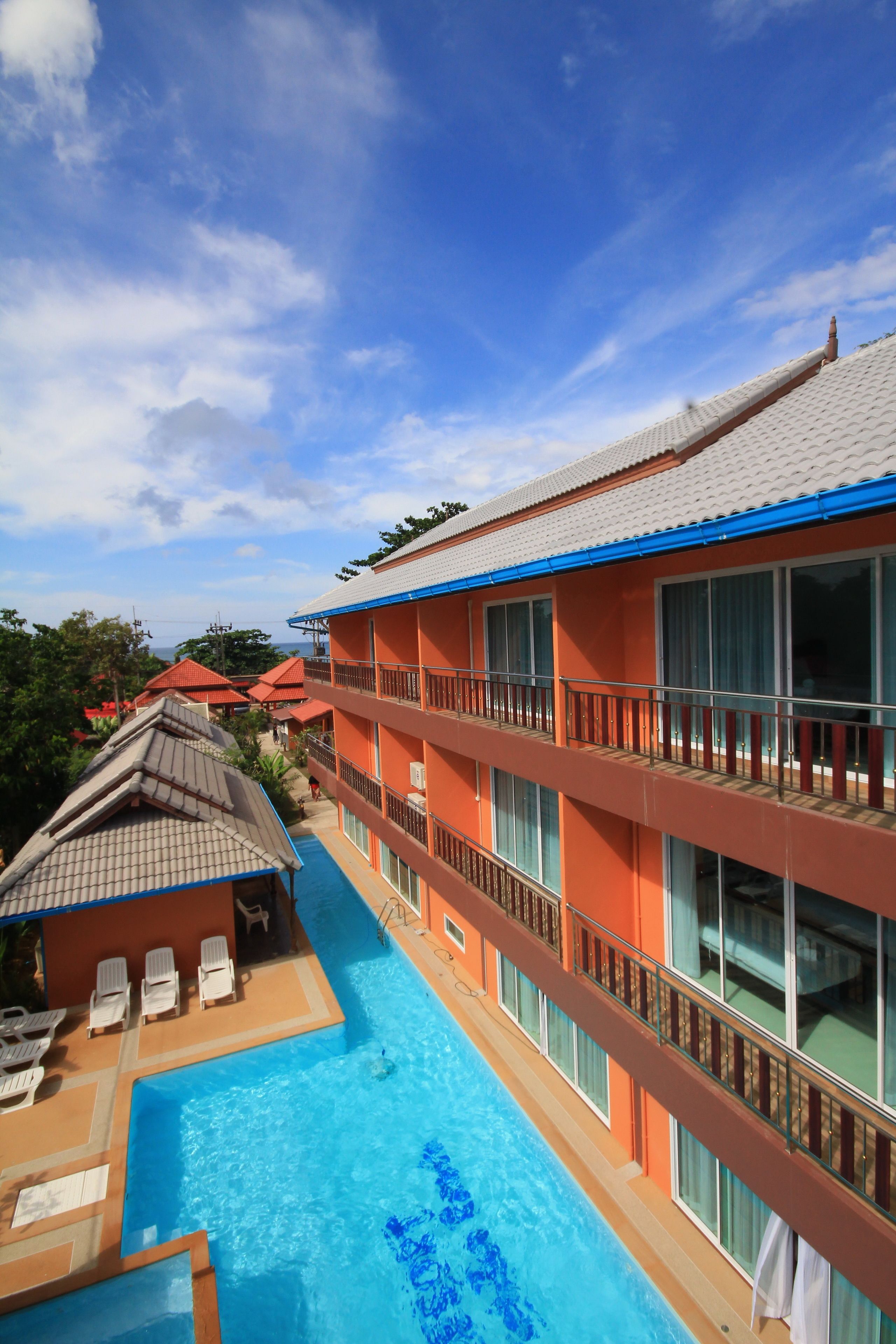 Hotel com piscina, várias varandas e vista da região circundante.