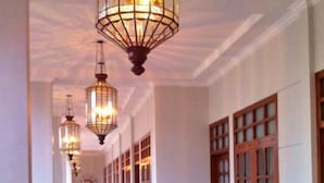 A hallway with wooden doors and a tiled floor. - De Halimun Guest House (Bandung)