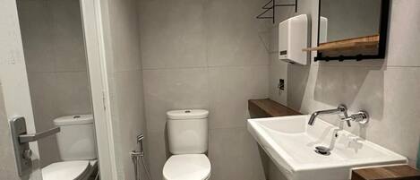 Un baño moderno con inodoro, bidé y lavamanos.