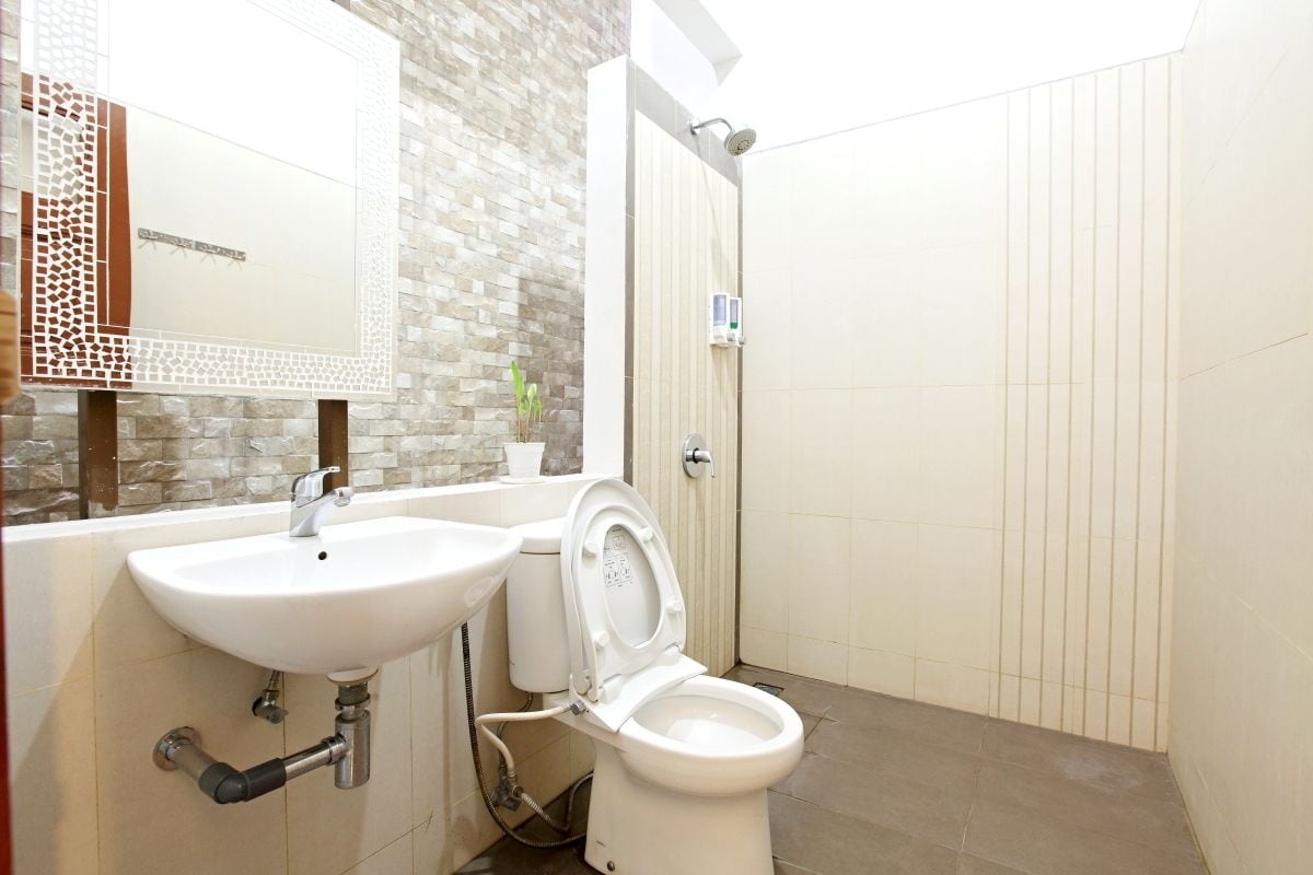 A bathroom with a white sink, toilet, and shower.