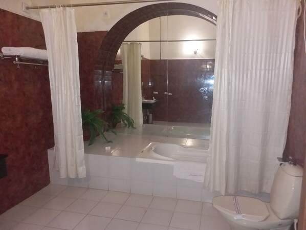 Un baño con bañera, inodoro y lavamanos.
