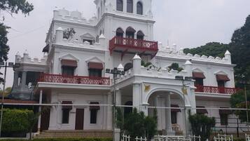 A large, white building with multiple balconies and a flag.