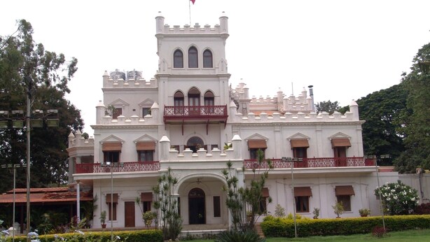 Un edificio grande y blanco, de estilo castillo, con varios balcones y ventanas arqueadas.
