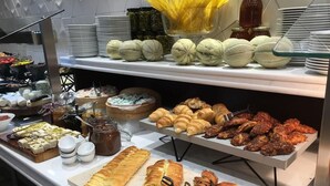 Ein reichhaltiges Buffet mit verschiedenen Speisen, darunter Backwaren, Fleisch und Beilagen.