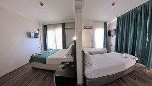 A hotel room with two beds, a flat-screen TV mounted on the wall, and an air conditioning unit. - HBS Hotel (Kusadasi)
