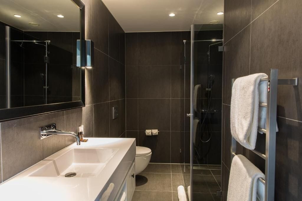 Ein modernes Badezimmer mit einem großzügigen Waschbecken, Toilette und einer Duschkabine.