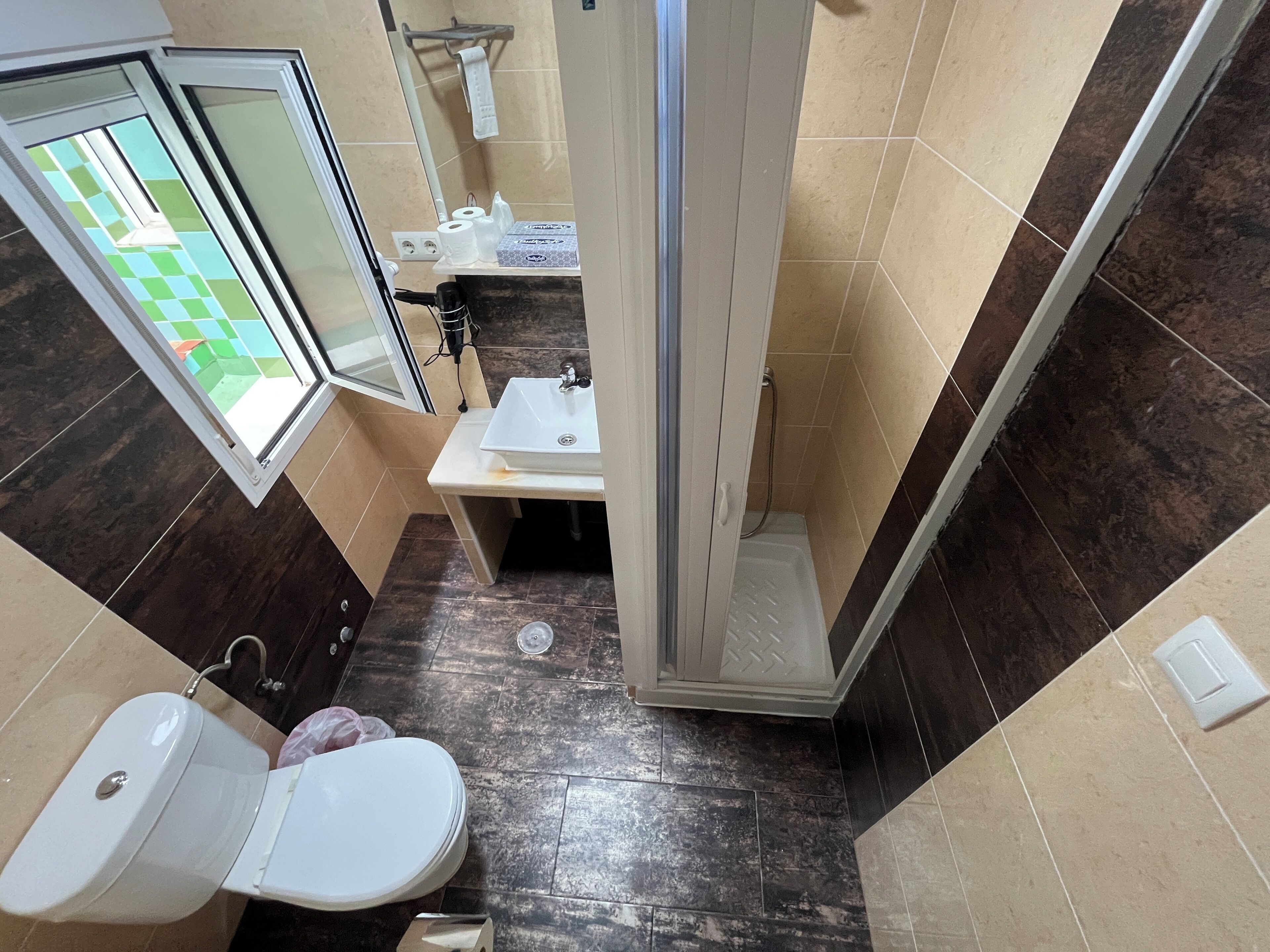 A bathroom with a toilet, sink, and shower.