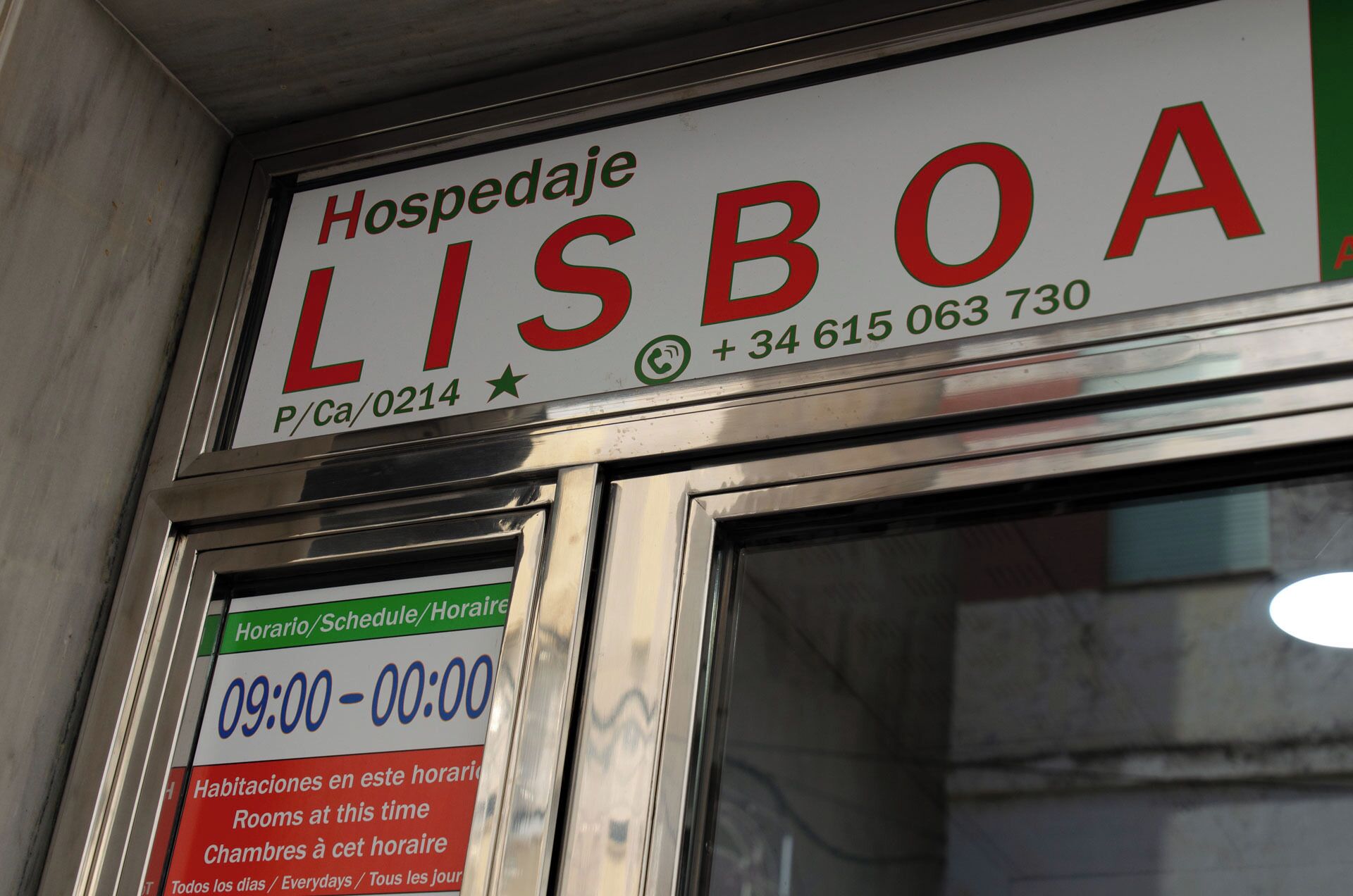 Placa de hotel com o nome "HOSPEDAJES LISBOA" e um número de telefone.