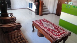 A spacious lobby with a wooden staircase, a reception desk, and a patterned rug. - Marany Guesthouse (Kampot)