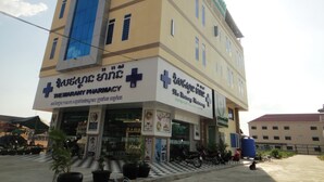 A multi-story building with a pharmacy on the ground floor. - Marany Guesthouse (Kampot)