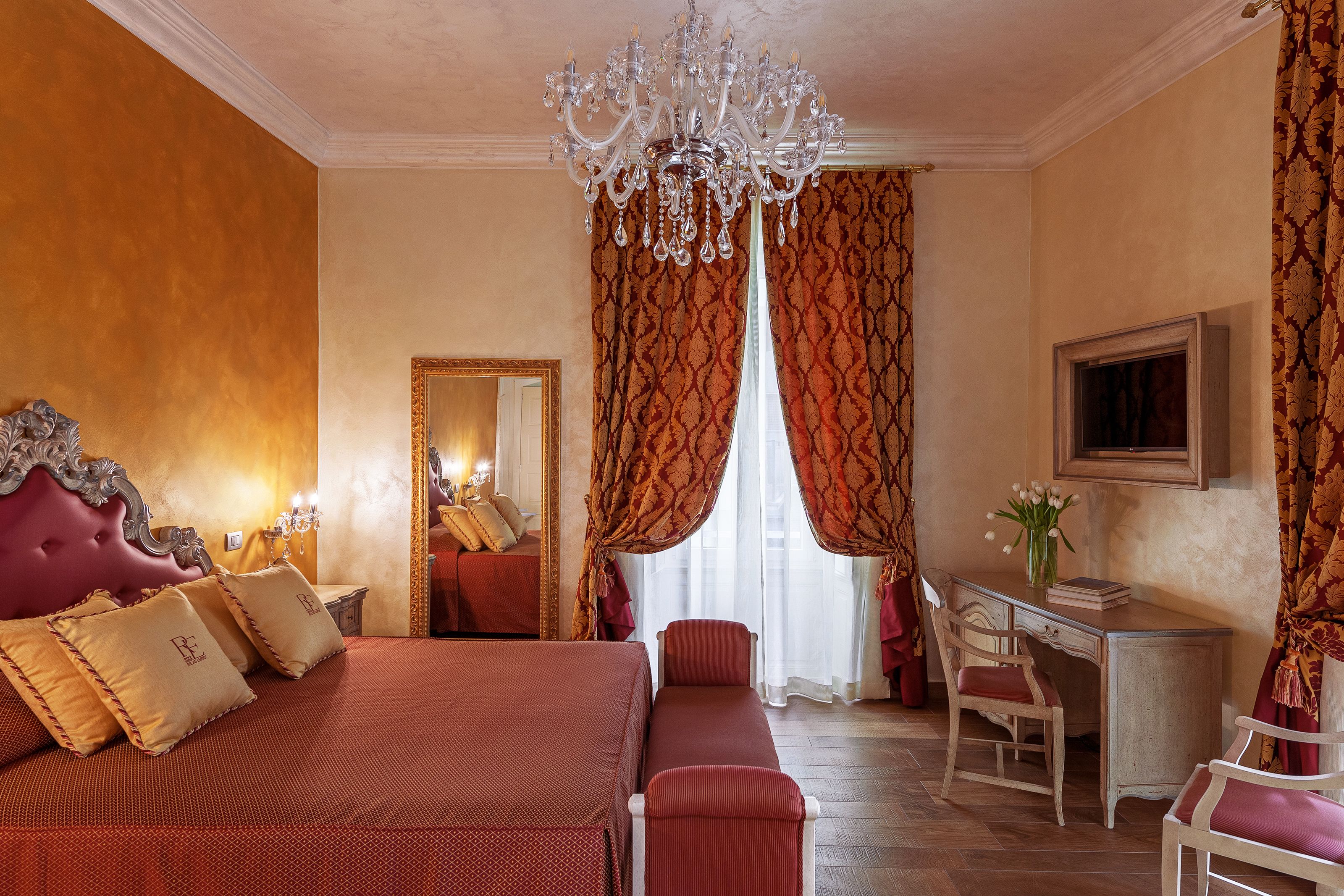 Een hotelkamer met een groot bed, een bureau en een stoel.