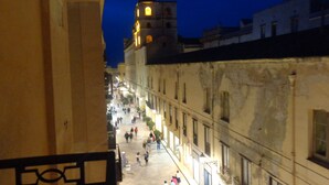A nighttime view of a historic street with a prominent tower in the background.