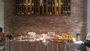 A buffet table with various dishes and a wine rack above it.