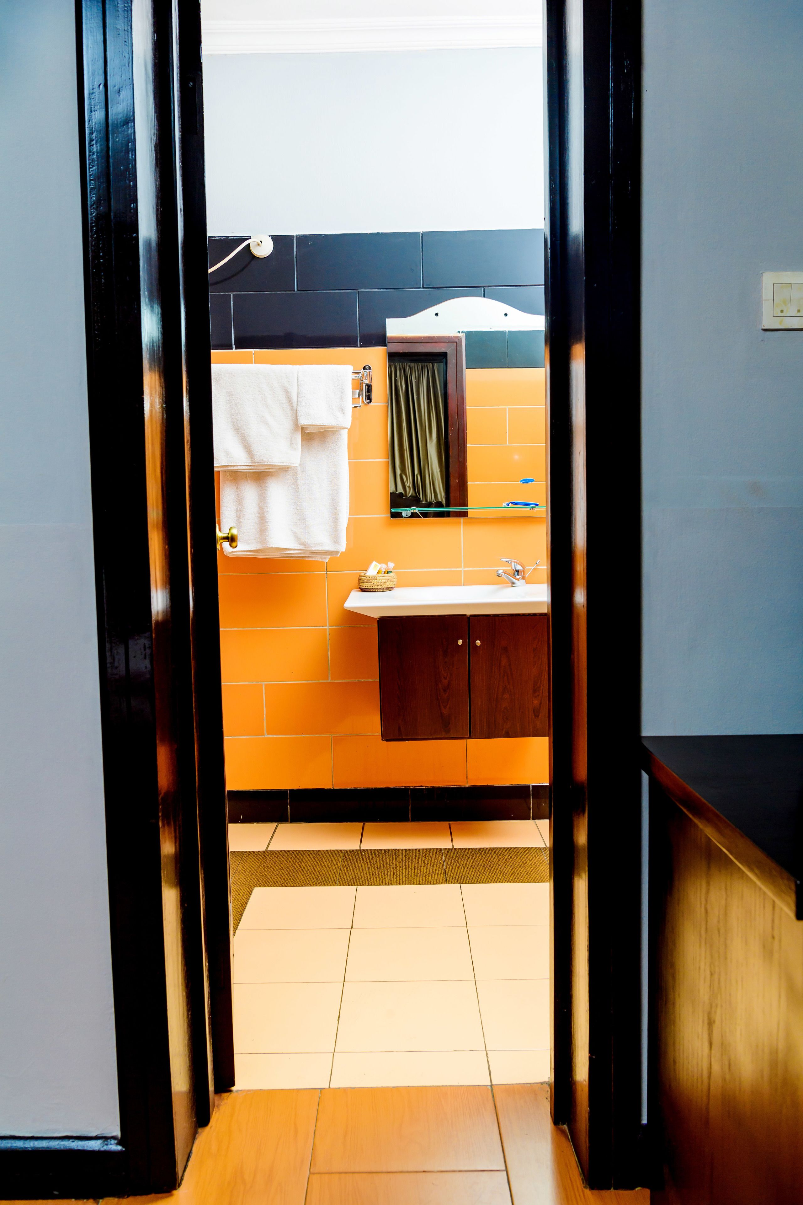 A bathroom with a sink, mirror, and towel hanging on the wall.