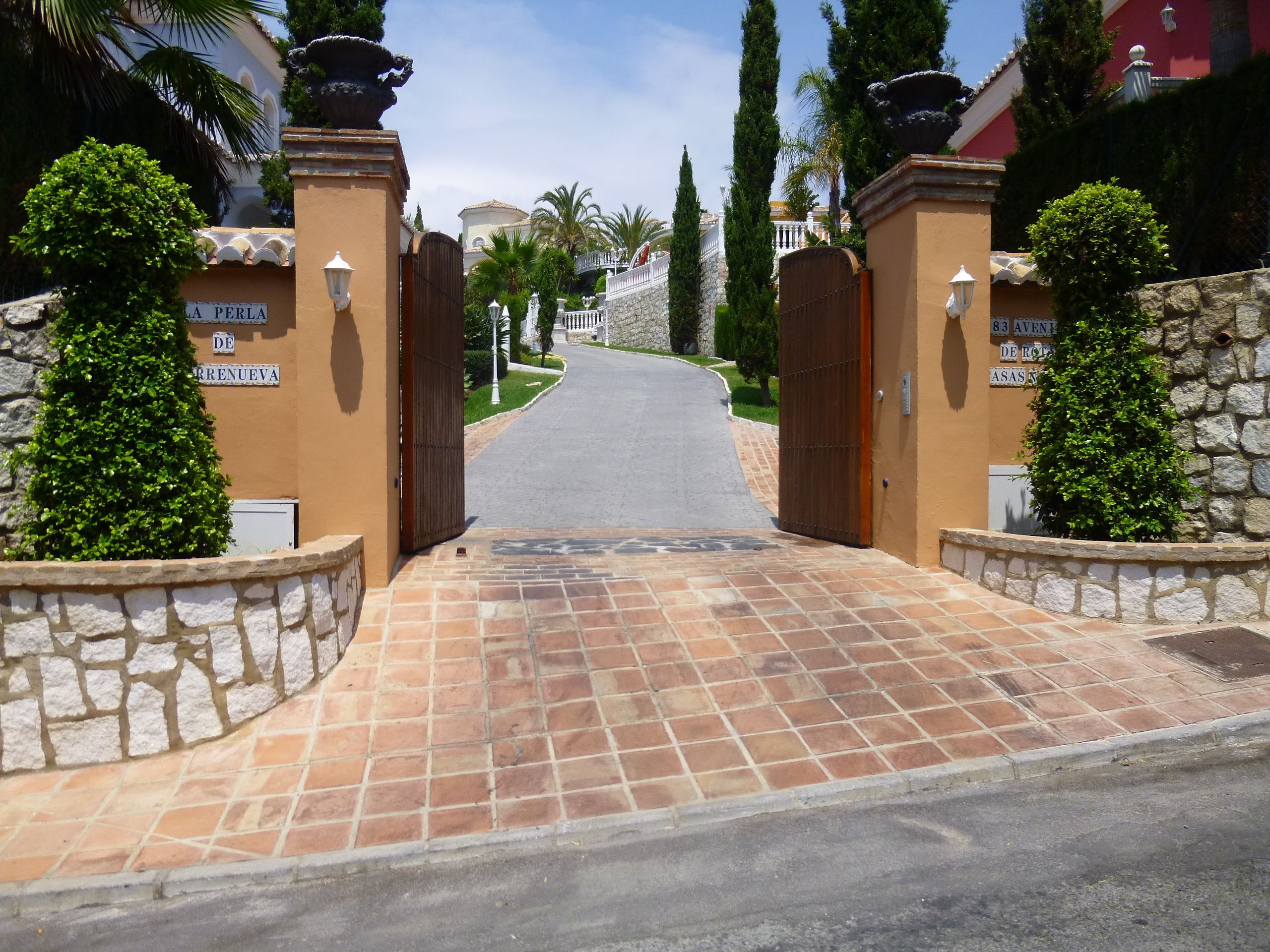 Una entrada cerrada con un camino de entrada pavimentado que conduce a un edificio.