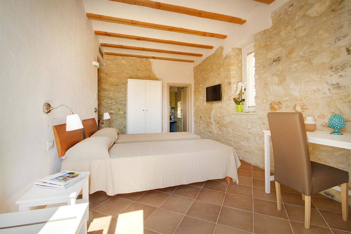 Une chambre à coucher avec un lit, des tables de chevet, un bureau et une chaise.