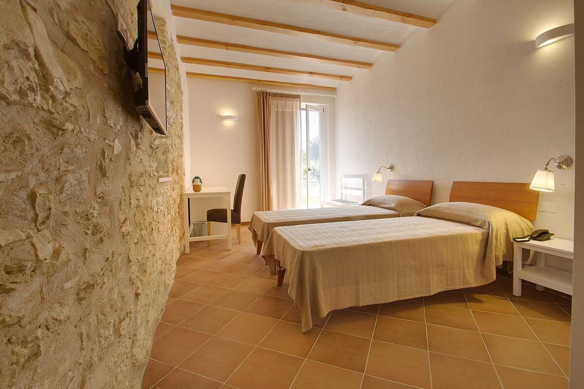 Une chambre avec deux lits, un bureau et une chaise.