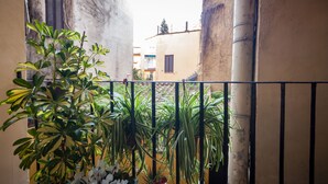 A balcony with potted plants and a view of buildings in the background. - Babuccio Art Inn (Rome)
