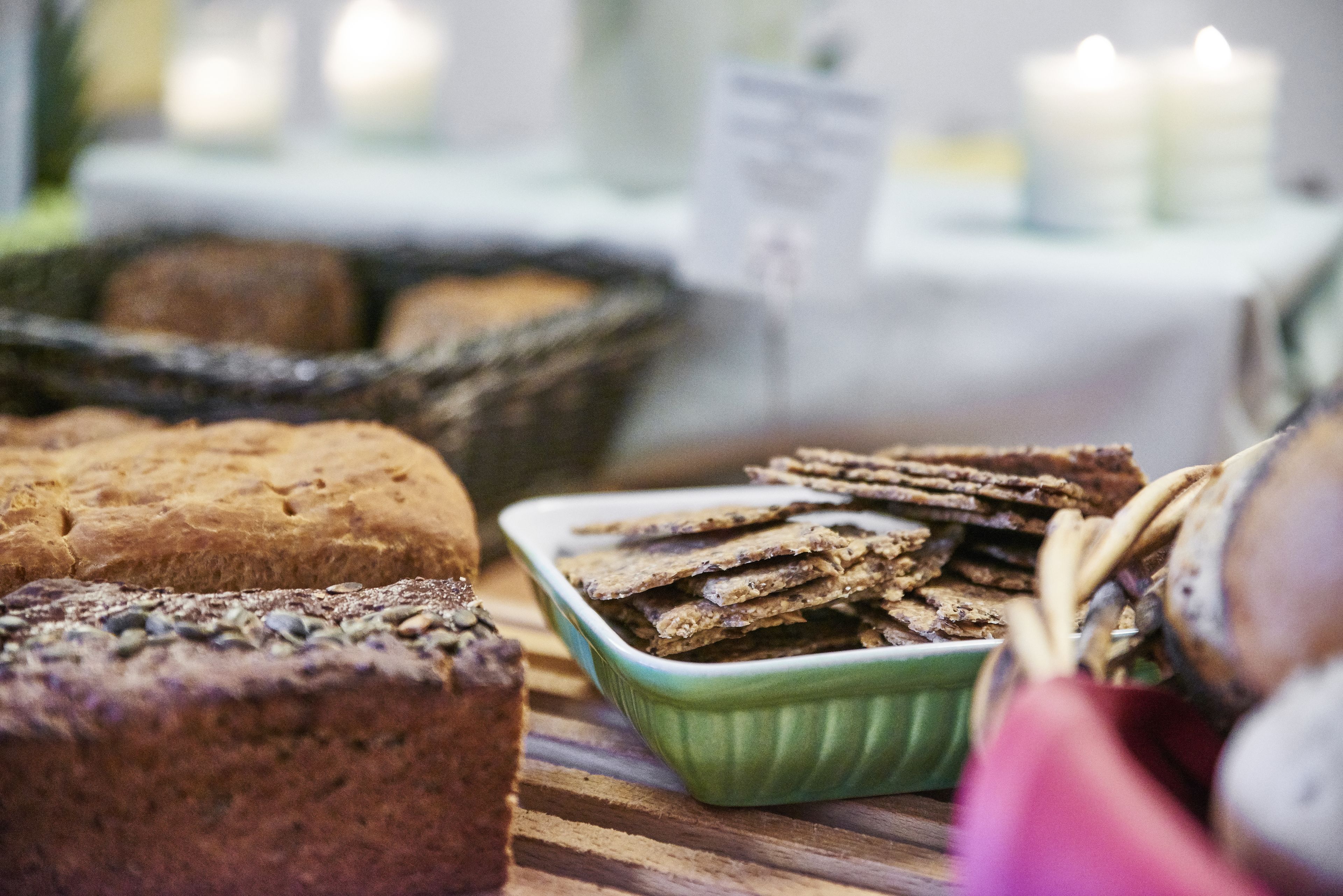 A variety of baked goods, including bread and crackers, displayed on a wooden table.