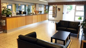 A reception area with a counter, seating, and a bookshelf.