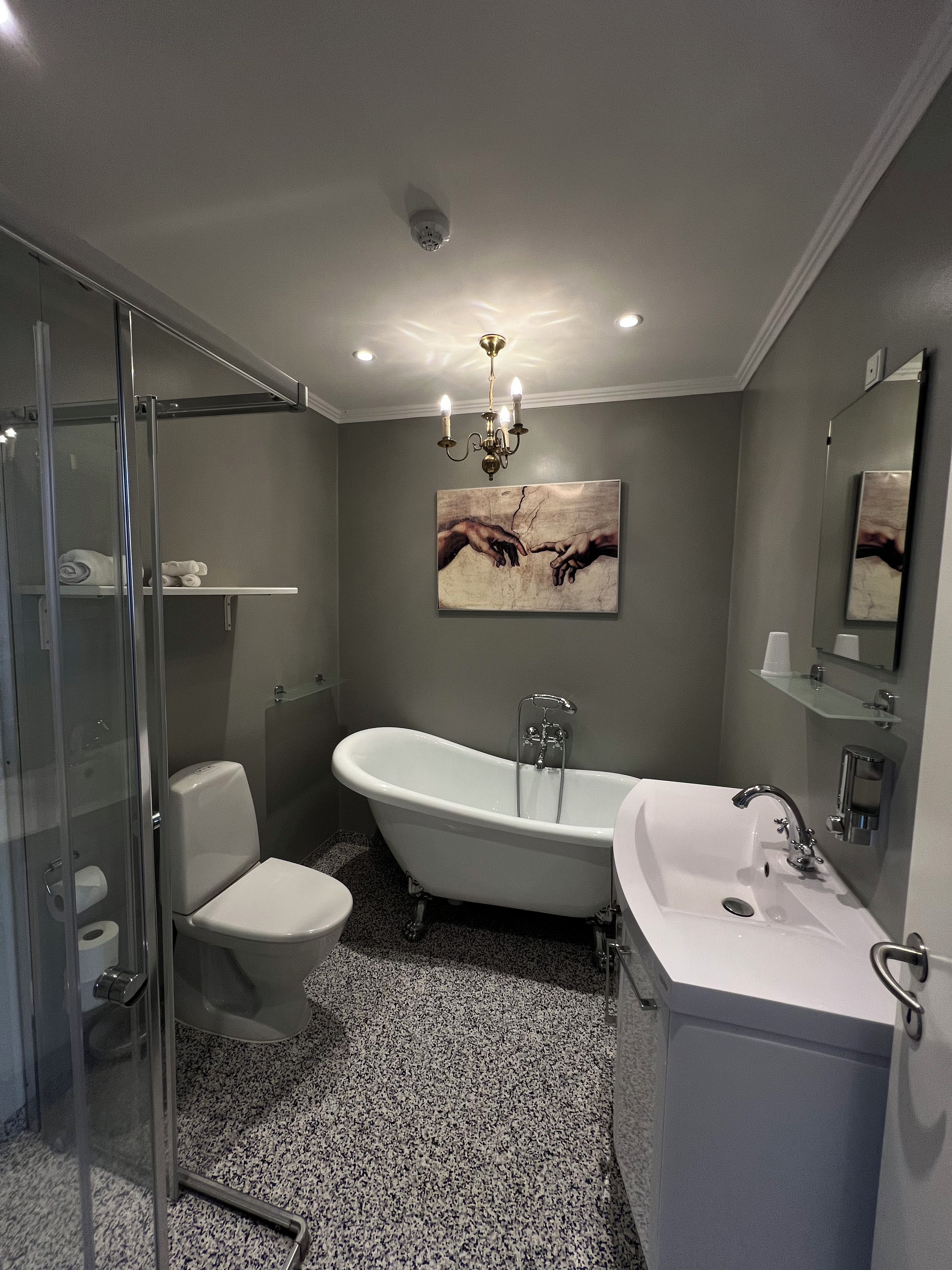 Un baño con una bañera independiente, inodoro, lavabo y cabina de ducha de cristal.