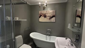 Un baño con una bañera independiente, inodoro, lavabo y cabina de ducha de cristal.