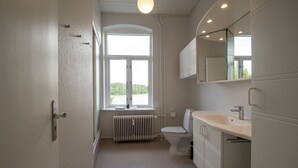 Un baño moderno con inodoro, lavabo y espejo.