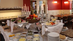 A buffet setup with various food items and a candle centerpiece. - Det Gamle Rådhus (Grasten)