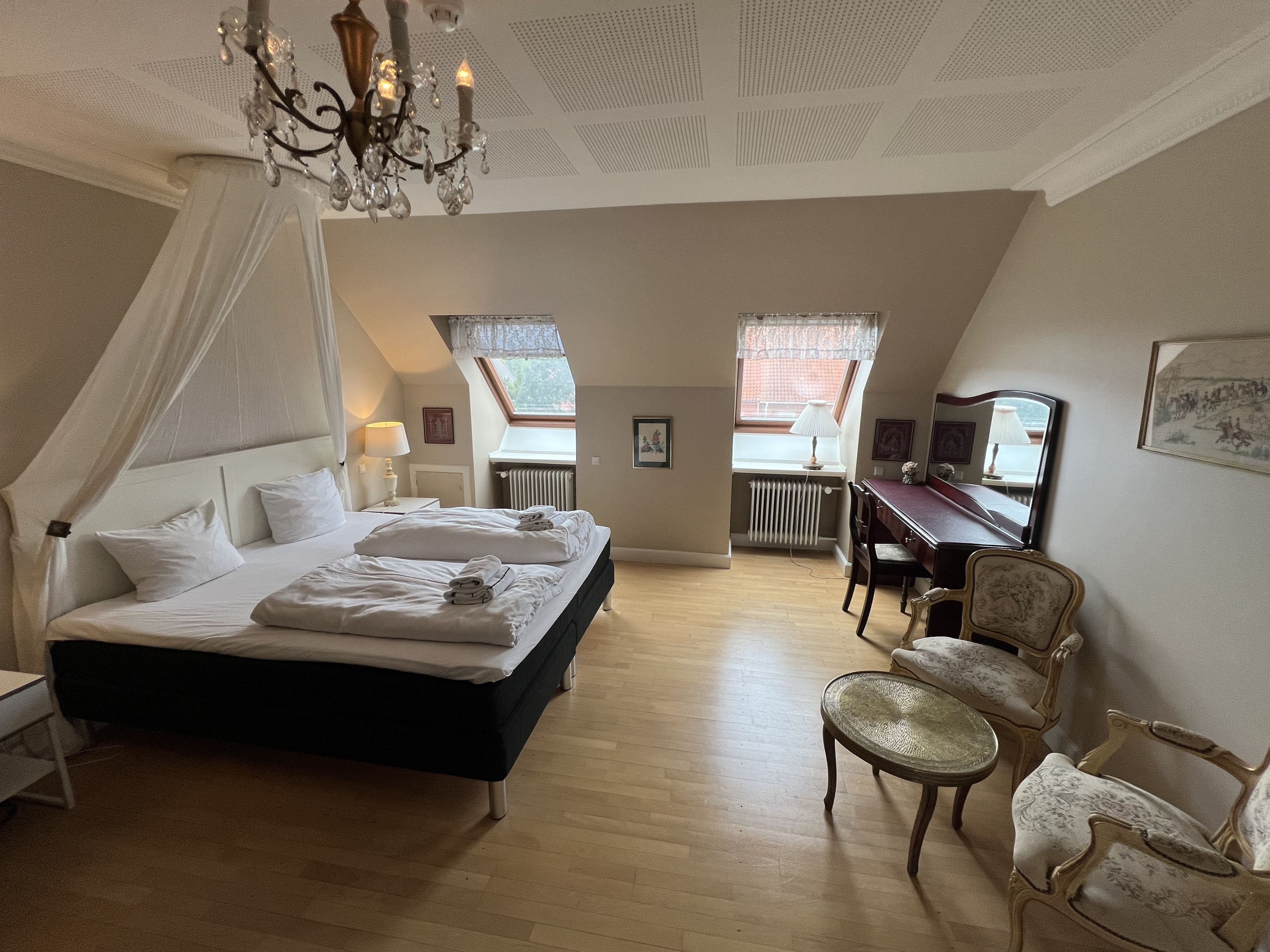 Une chambre à coucher avec un grand lit, un bureau et une chaise.