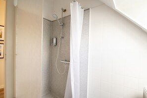 A shower with a glass door, a handheld showerhead, and a wall-mounted control panel. - Det Gamle Rådhus (Grasten)