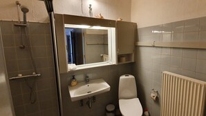 A bathroom with a shower, sink, toilet, and a mirror above the sink. - Det Gamle Rådhus (Grasten)
