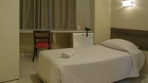 A hotel room with a bed, a desk, a chair, a flat-screen TV, a phone, and a wall-mounted light. - Hotel Elevado (Porto Alegre)