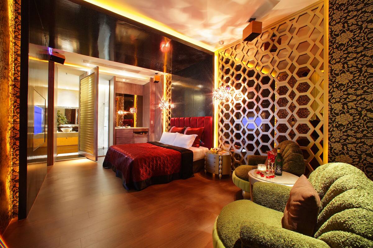 Een moderne hotelkamer met een groot bed, een zithoek en uitzicht op de keuken.