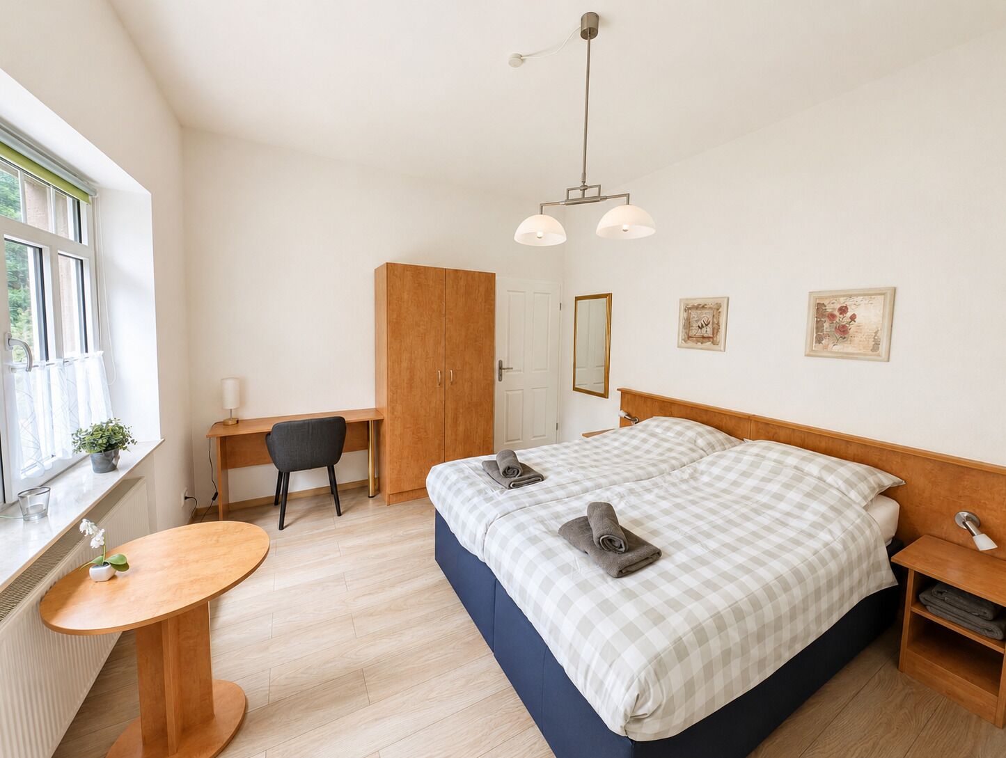 Ein Schlafzimmer mit Bett, Schreibtisch, Stuhl und einem kleinen Tisch.