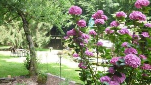 A garden with pink flowers and a tree. - Wald Villa Üssbach (Alf)
